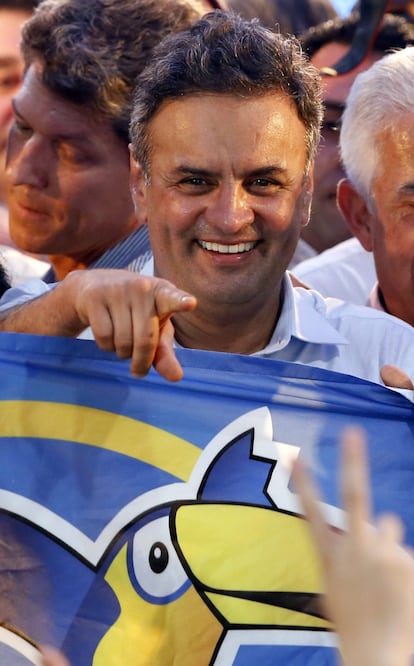 Aécio segura bandeira do PSDB em evento em Curitiba, no dia 13.