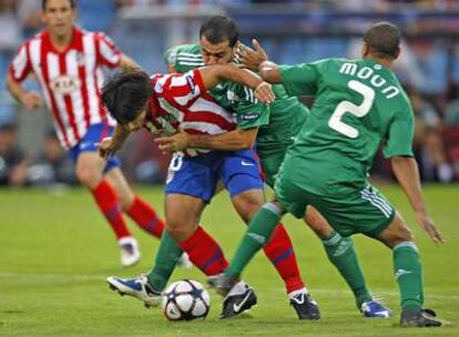 Agüero trata de abrirse paso entre dos adversarios.