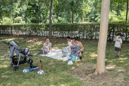 Ana González, en el centro, junto a su madre, su abuela y su hermano, descansa bajo la sombra de los árboles del Retiro.
