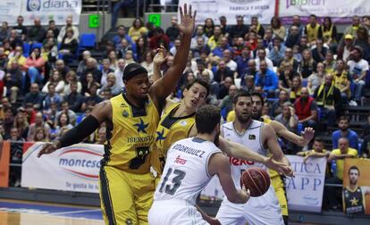 Joseph Jones (i) y Rodrigo San Miguel (c, detrás), del Iberostar Tenerife, presionan al base del Real madrid Sergio Rodríguez ante el pivot Felipe Reyes.