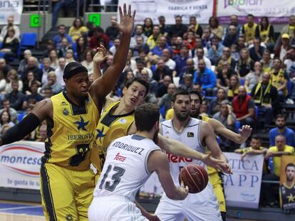 Joseph Jones (i) y Rodrigo San Miguel (c, detr&aacute;s), del Iberostar Tenerife, presionan al base del Real madrid Sergio Rodr&iacute;guez ante el pivot Felipe Reyes.