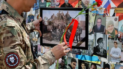 Un hombre con uniforme de Wagner coloca una flor en un homenaje por los miembros de esta compañía privada de seguridad fallecidos en la batalla de Tinzaouaten, en el norte de Malí, el pasado 4 de agosto en Moscú.