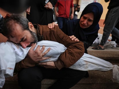 Jamil al-Agha y su esposa lloran mientras abrazan el cadáver de uno de sus dos hijos muertos en un bombardeo israelí en Jan Yunis, este domingo.