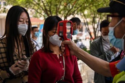 Controle de temperatura em passageiros recém-chegados na estação de trem de Hankou, em Wuhan.