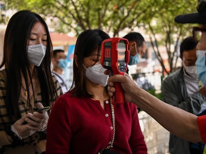 Controle de temperatura em passageiros recém-chegados na estação de trem de Hankou, em Wuhan.