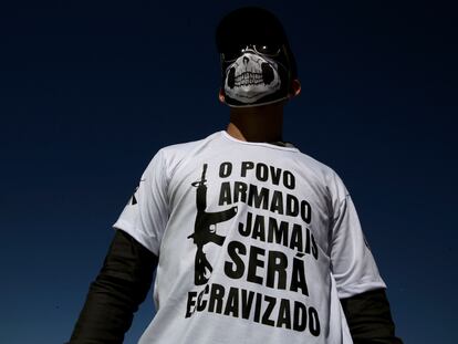 Un hombre usa una camiseta con la leyenda "el pueblo armado nunca será esclavizado", durante una protesta a favor de las armas, en Brasilia.