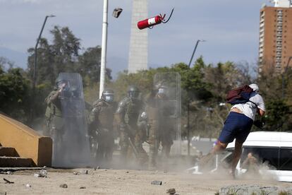 Manifestantes se enfrentan a la policía antidisturbios durante una protesta después de que el joven Antony Araya, de 16 años, cayera de un puente mientras los agentes intentaban arrestarlo durante los enfrentamientos del viernes en Santiago de Chile. El policía que empujó al joven al río Mapocho fue detenido el sábado por estar involucrado en un posible delito de homicidio frustrado.