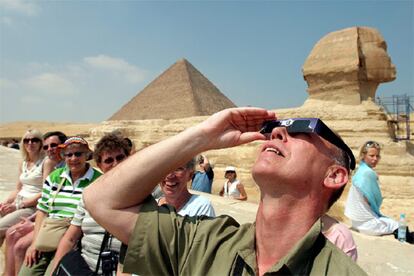 Un turista holandés observa el eclipse solar con gafas especiales en la zona de las pirámides en El Cairo, Egipto. Este país ha sido uno de los lugares de la Tierra donde el eclipse se ha mostrado en todo su esplendor, tapando casi en su totalidad la superficie del Sol.