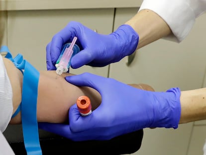 Un trabajador sanitario extrae sangre de una paciente para realizar el test serológico.