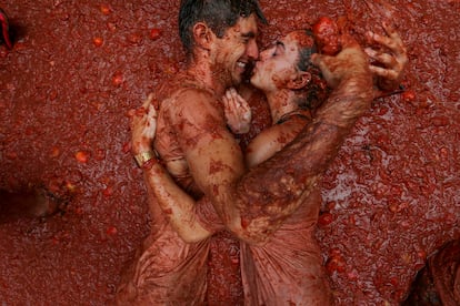 Una pareja se besa entre la pulpa de tomate.