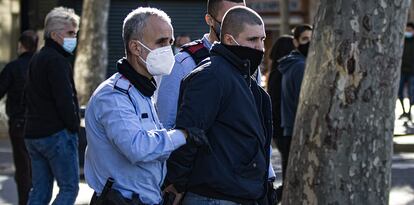 Agentes de los Mossos d'Esquadra detienen a uno de los ultras, este domingo en Barcelona