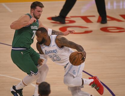 LeBron intenta superar el marcaje de Doncic.