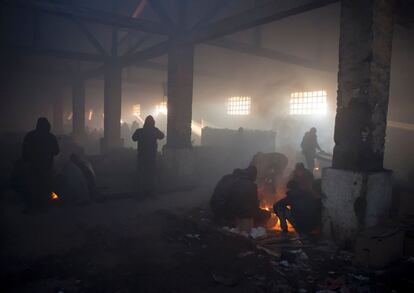 "Es indignante ver que, pese a todas las promesas comunitarias y anuncios, los hombres, las mujeres y los niños viven en tiendas de campaña bajo una lluvia helada", según la organización. En la imagen, los migrantes han encendido fogatas dentro de un almacén abandonado que usan como refugio, en Belgrado (Serbia).