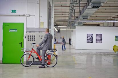 Bertram Schultze, desarrollador del proyecto MIB/ Auf AEG, subido a una bicicleta en el Hall 15.