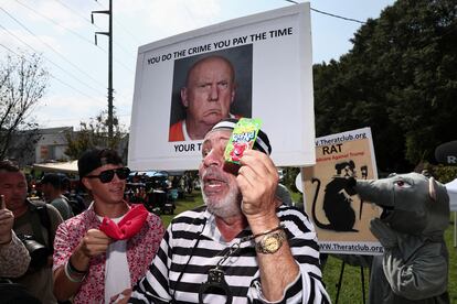 Un grupo de manifestantes anti-Trump sostienen pancartas en las que se pide la detención del ex mandatario. 