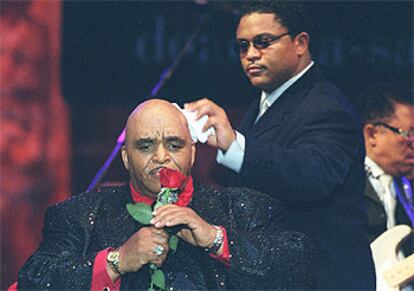 Solomon Burke en el escenario, mientras uno de sus hijos le seca el sudor de la cabeza.