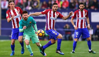 Messi lucha por un balón con Koke.