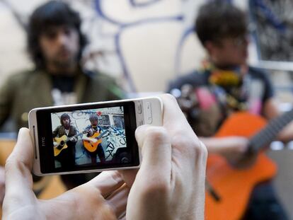 Uno de los participantes en el taller de videoclips para móviles grabando en el Raval.