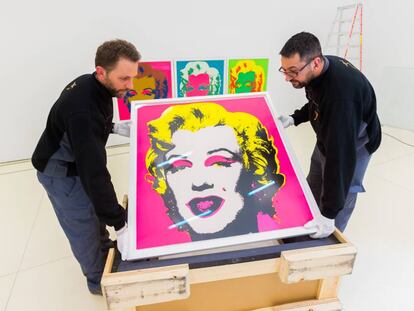 Operarios colocan las pinturas de Marilyn Monroe.