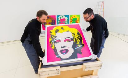 Operarios colocan las pinturas de Marilyn Monroe.