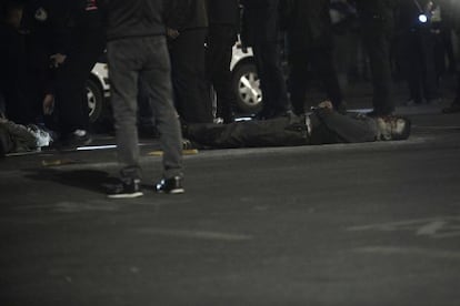 Um homem estendido no chão depois de receber um disparo da polícia.