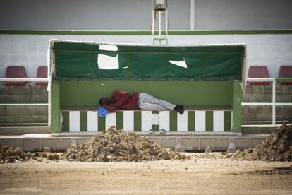 Un migrante subsahariano descansa en un campo del polideportivo de Los Cortijillos, Los Barrios, Cádiz.