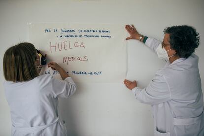 Dos médicas colocan una pancarta casera en el centro de salud de Narón (A Coruña) durante el primer día de huelga.
