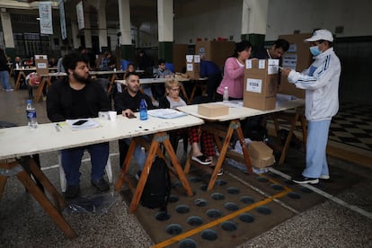A las ocho de la mañana han abierto las urnas. Según los últimos datos, se ha registrado una participación del 74% del padrón electoral. En la imagen, un votante deposita su papeleta en una urna en un colegio electoral, en Buenos Aires, este domingo.
