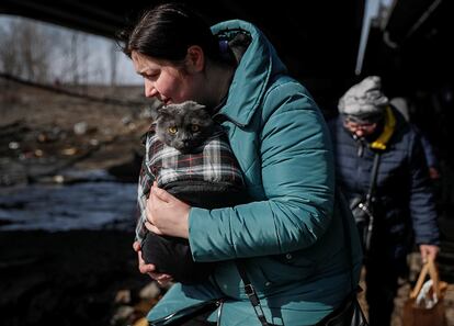 Ciudadanos de Irpin abandonan de la ciudad asediada por las tropas rusas, este sábado. El líder ruso, Vladímir Putin, acusó hoy a las fuerzas "nacionalistas" ucranianas de violar el derecho internacional humanitario en las zonas de hostilidades en Ucrania tras la ofensiva rusa, en una conversación telefónica con el presidente francés, Emmanuel Macron, y el canciller alemán, Olaf Scholz, según informó el Kremlin en un comunicado.