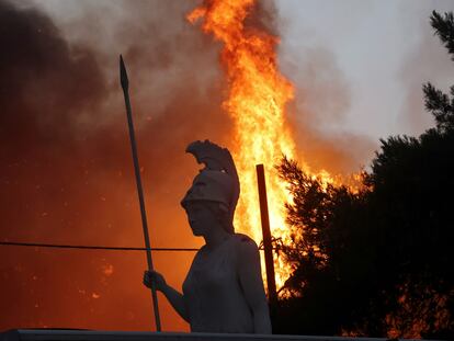 Una estatua de Palas Atenea, diosa griega de la guerra, rodeada por el fuego en el suburbio ateniense de Varympompi la noche del martes.