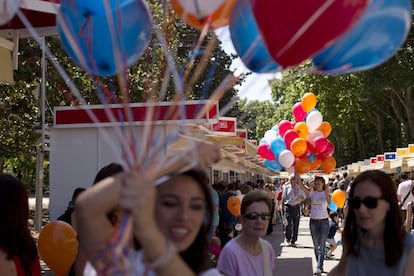 Unas animadoras infantiles regalan globos a los niños durante la Feria del Libro de Madrid.