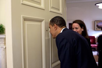 Obama mira a través de la mirilla que hay en la puerta que separa el Despacho Oval y el lugar donde se encuentra la mesa de trabajo de Katie Johnson (Fotografía: Casa Blanca).