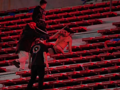 Un aficionado de Universidad de Chile es agredido por hinchas de Independiente, este miércoles en Buenos Aires.