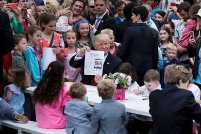 Donald Trump muestra una nota que el mismo escribió, durante el 'Easter Egg Roll' de la Casa Blanca.