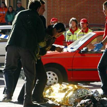 Dos policías de paisano sujetan a la hija de la fallecida delante de su cadáver.