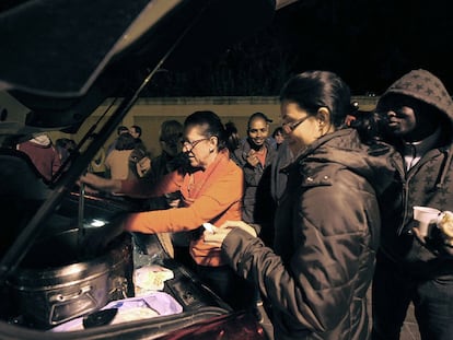 Dos de las voluntarias de Amigos de la Calle distribuyen la sopa de verduras entre varios <i>sin techo</i> de Valencia.