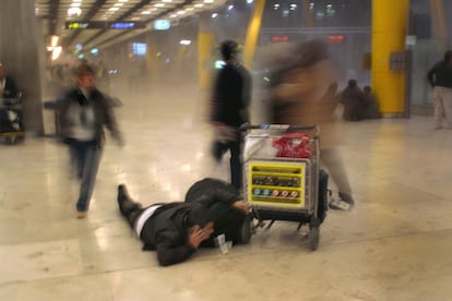 Um homem se joga ao chão e outras pessoas correm pelos corredores do aeroporto de Barajas (Madri) depois da explosão de um carro-bomba colocado pelo ETA em um estacionamento do Terminal 4. O atentado rompeu o cessar-fogo que o grupo terrorista tinha iniciado nove meses antes. Dois jovens equatorianos faleceram na brutal explosão.