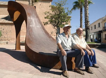 Un par de hombres descansan en la estatuta de Granátula de Calatrava (Ciudad Real)