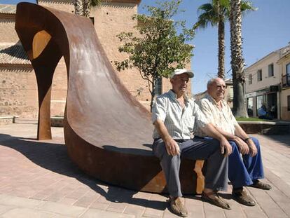 Un par de hombres descansan en la estatuta de Granátula de Calatrava (Ciudad Real)