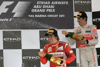 Fernando Alonso and Jenson Button celebrate on the podium in Abu Dabi.