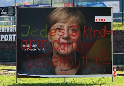 Pintada antiinmigrantes en un cartel electoral de Angela Merkel.