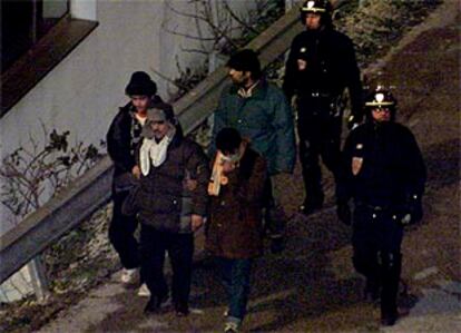 Policías franceses custodian a inmigrantes clandestinos detenidos cerca del túnel del canal de la Mancha.