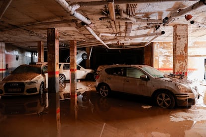 Vehículos en el interior de un garaje del que ya se ha achicado todo el agua este lunes en Paiporta (Valencia).