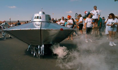 A bicycle-powered flying saucer sputters by the crowd gathered on Main Street Saturday, July 5, 1997, in Roswell, N.M