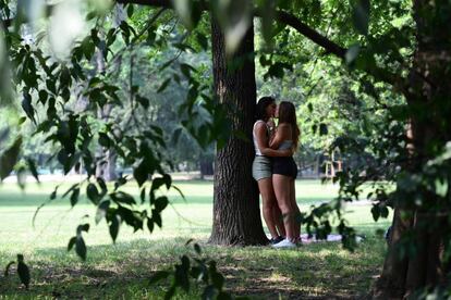 Una pareja se besa en un parque milanés.