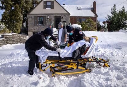 Los técnicos de emergencias médicas Eric Del Valle y Christian Amoroso transportan a una mujer de 77 años con síntomas de covid-19 a un hospital, el 17 de diciembre de 2020, en Yonkers, Nueva York. Mientras aumenta el número de casos en todo el país, los hospitales han comenzado a vacunar a los trabajadores de la salud con la vacuna de Pfizer-BioNTech.