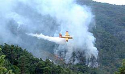 Un hidroavin descarga agua sobre el incendio en los mallos de Riglos.