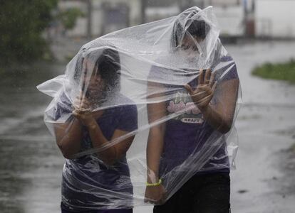 Residents filipins utilitzen bosses de plàstic per protegir-se de les pluges i dels forts vents portats pel tifó Hagupit.