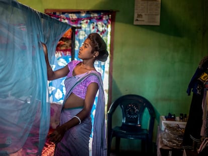 Una mujer coloca una mosquitera en su casa en Assam, India.