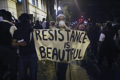 Una manifestante muestra una pancarta que dice "La resistencia es bonita", durante la tercera noche de protestas en Charlotte. 